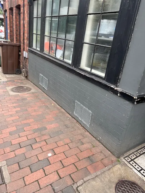 A brick sidewalk next to a building.