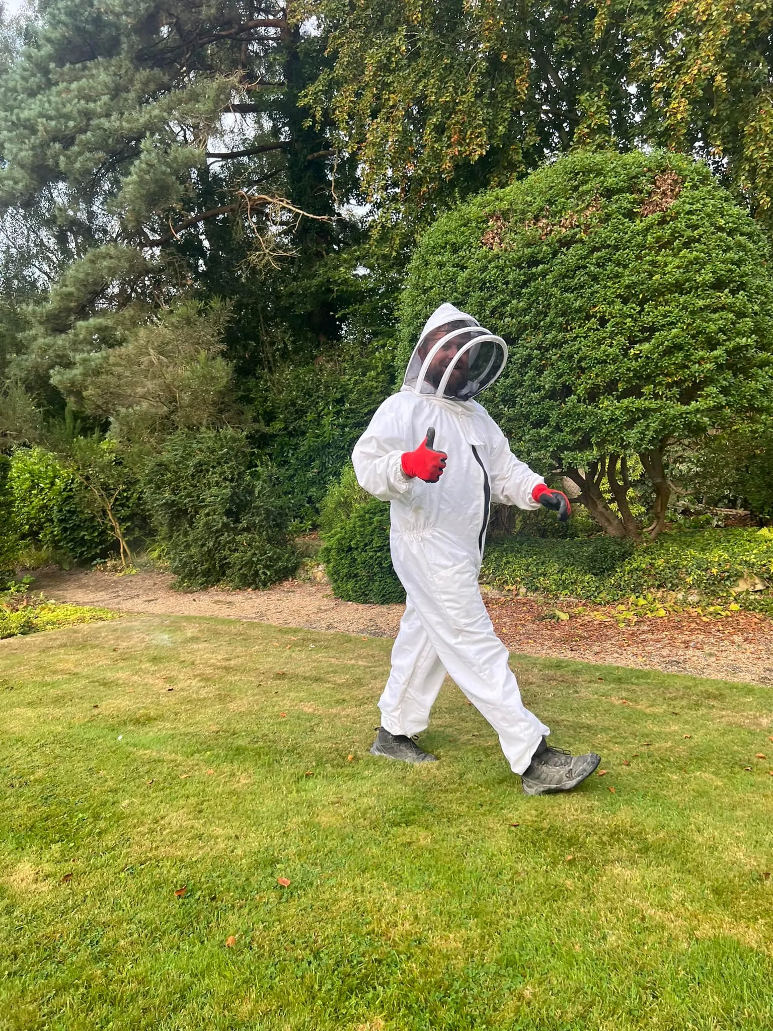 A man in a white suit is playing baseball.